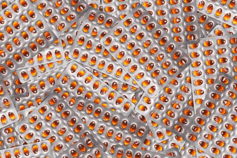 Orange pills texture. Silver blister background.