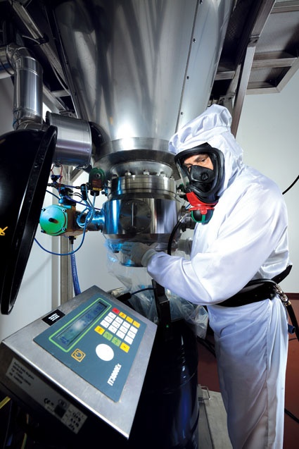 A worker fills a solid material in a clean room.