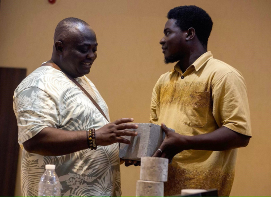 Evans Nartey (Founder & CEO; on the right) presenting a sample of geopolymer...