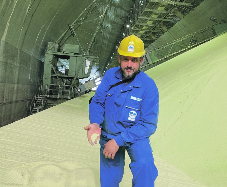 Ein SKW-Mitarbeiter zeigt in einer Lagerhalle den Stickstoffdünger, den...