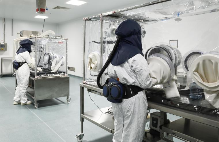 two workers performing experiments in gloveboxes.